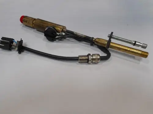 Düsenstock von Remeha mit zwei Metallrohren, Kabelanschluss und einer roten Kappe. Klare Sicht auf die Verbindungsteile und den Anschluss für die Elektronik.